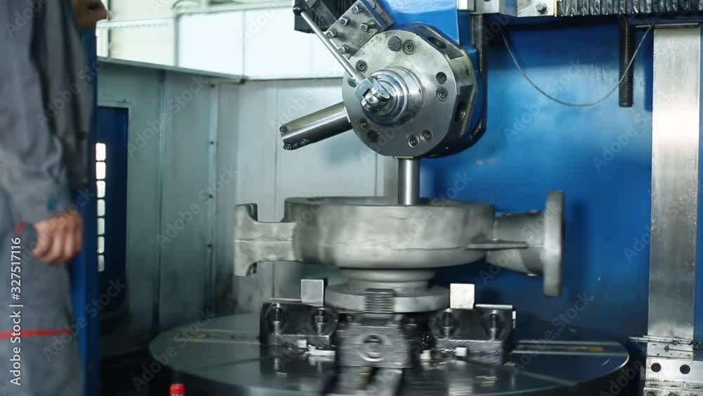 A worker at the factory makes a large spare part. Large lathe A worker at the factory makes a large spare part. Large lathe