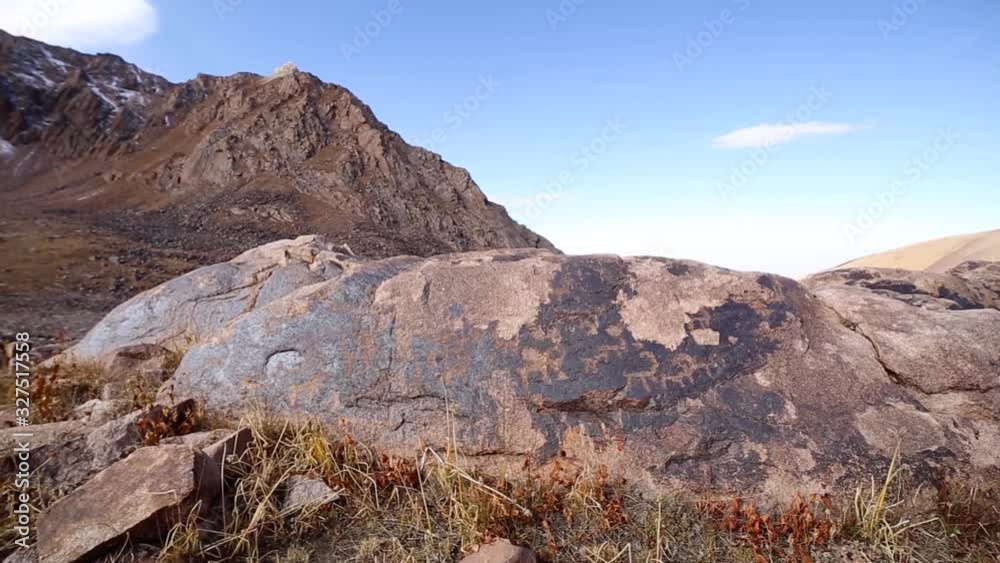 Drawings of ancestors. Petroglyphs on a rock in the mountains Drawings of ancestors. Petroglyphs on a rock in the mountains
