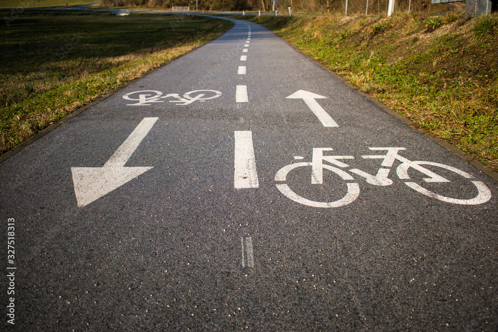 Bicycle path, two way cycling track with bicycle signs painted white Bicycle path, two way cycling track with bicycle signs painted white