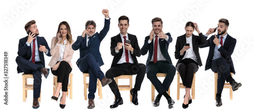 Team of 7 businessmen celebrating and talking on their phones