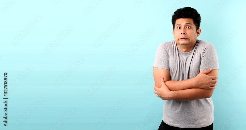 Portrait Handsome Asia man feeling cold on blue background in studio With copy space. Portrait Handsome Asia man feeling cold on blue background in studio With copy space.