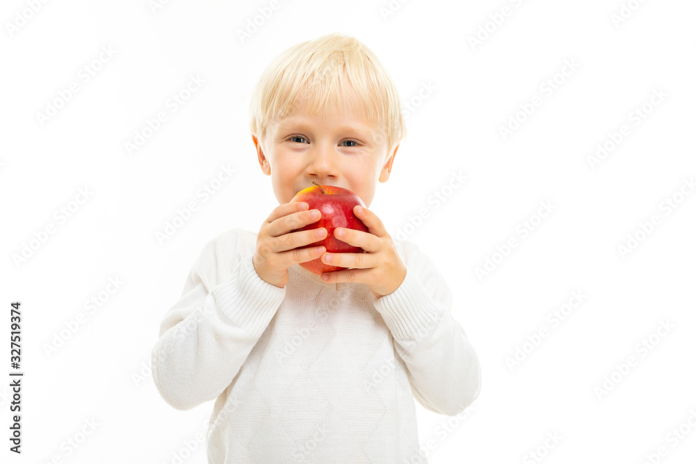 Little beautiful boy with blonde hair eats an apple, picture isolated on white background Little beautiful boy with blonde hair eats an apple, picture isolated on white background