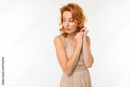 Cheerful woman with fair red hair in beautiful dress smiles, picture isolated on white background