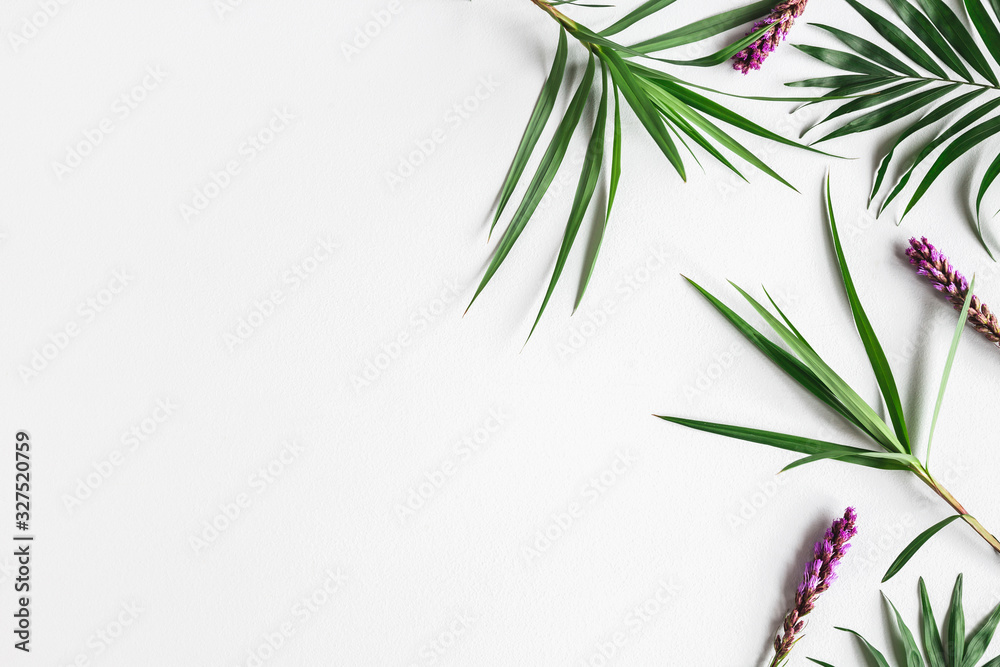 Fototapeta premium Summer composition. Tropical flowers and leaves on gray background. Summer concept. Flat lay, top view, copy space