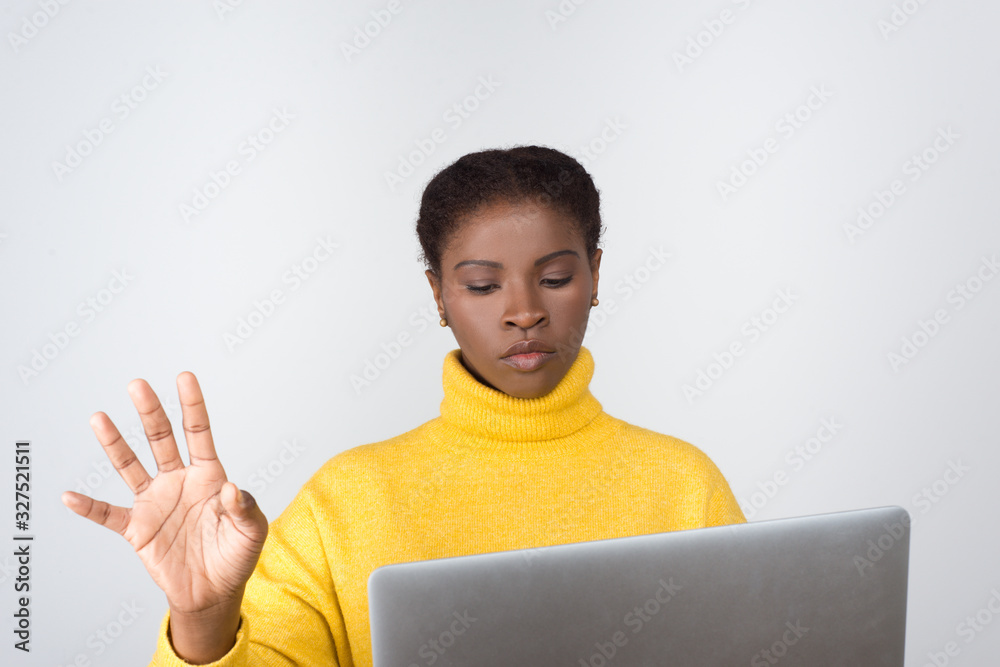 Thoughtful developer holding laptop and touching virtual screen. Concentrated young lady working with modern device. Technology concept Thoughtful developer holding laptop and touching virtual screen. Concentrated young lady working with modern device. Technology concept