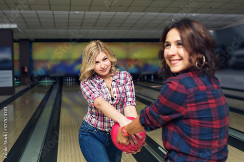 two funny girls snatch bowling ball from each other