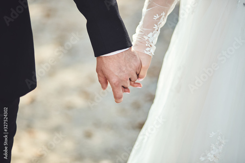 loving couple holding hands on them wedding day