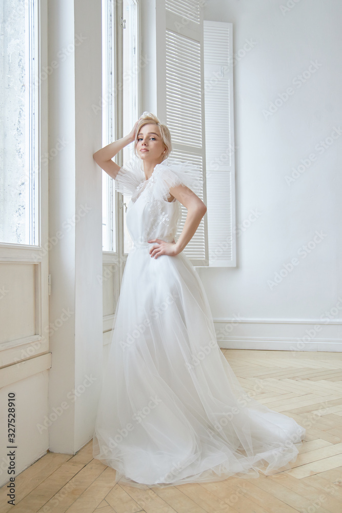 Luxurious white wedding dress on the girl's body. New collection of wedding dresses. Morning bride, a woman waiting for the groom before the wedding ceremony. Young bride in a long dress Luxurious white wedding dress on the girl's body. New collection of wedding dresses. Morning bride, a woman waiting for the groom before the wedding ceremony. Young bride in a long dress