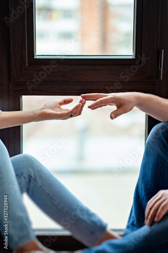 woman and man hand touch their fingers on window