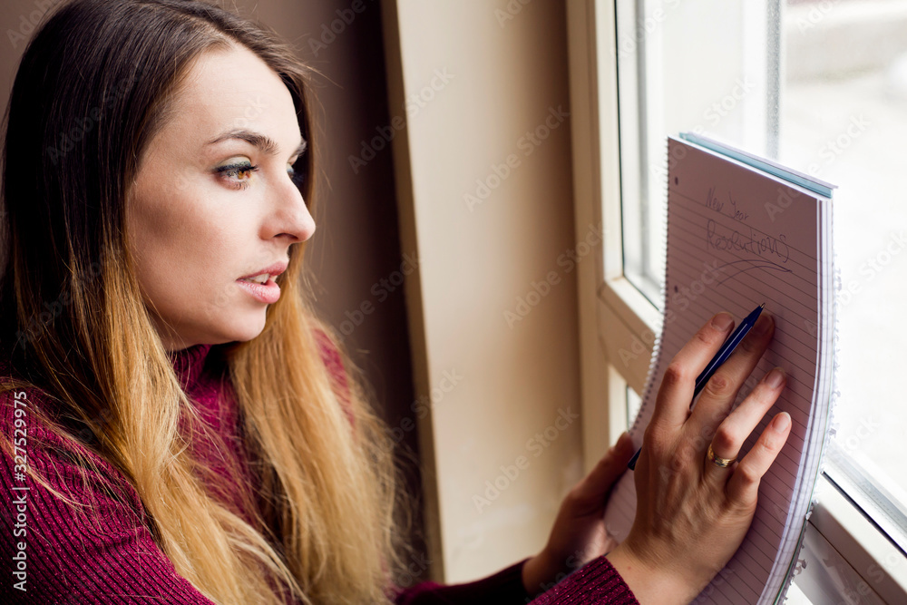 woman writing in a note book at home woman writing in a note book at home