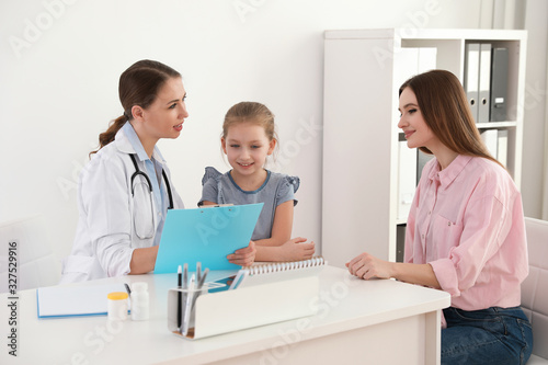 Mother and daughter visiting pediatrician. Doctor working with patient in hospital