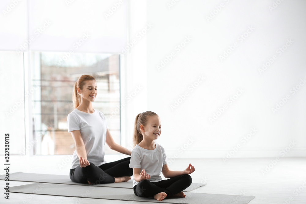 Mother and daughter in matching sportswear doing yoga together at home  Stock Photo | Adobe Stock
