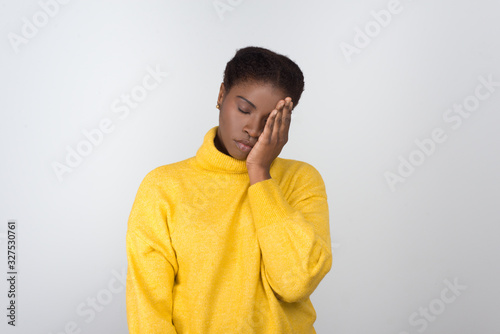 Tired African American woman holding hand on face. Exhausted young lady with closed eyes. Fatigue concept photo