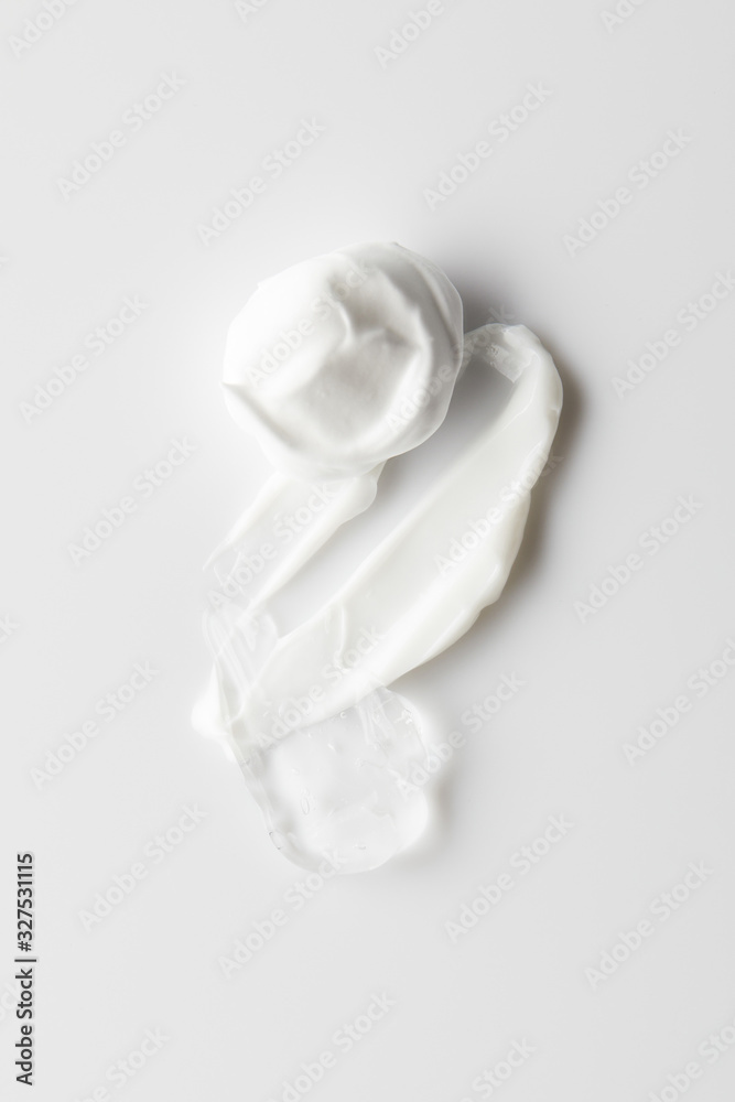 Top view of cosmetic cream brushstrokes and gel on grey background Top view of cosmetic cream brushstrokes and gel on grey background