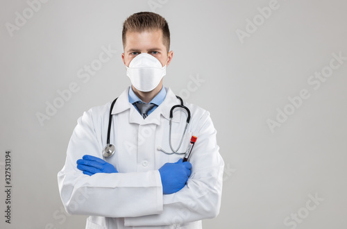 Health worker wearing a respiratory mask  holding the Coronavirus Covid-19 blood bample 