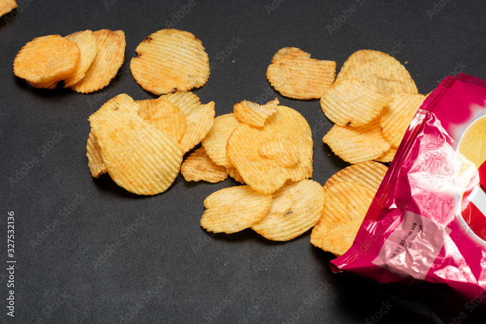 Pile of potato chips. Crisps on background. Potato chips is snack in bag