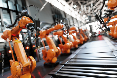 Robotic arms along assembly line in modern factory. photo