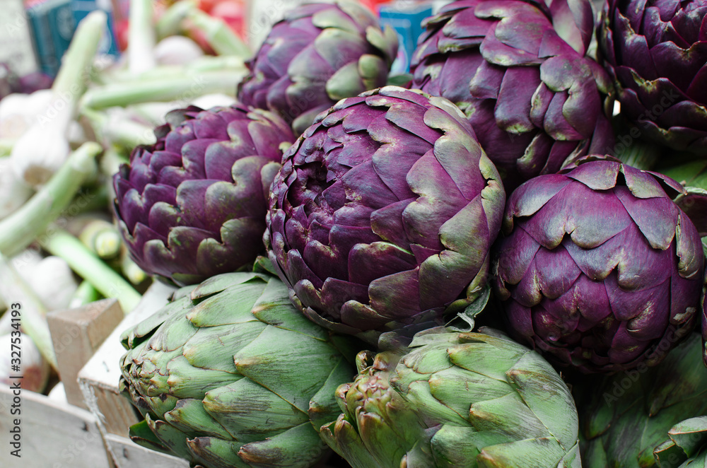 Fototapeta premium Fresh ripe purple artichokes in the fruit market