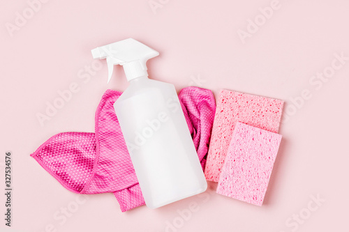 Detergents and cleaning accessories  in pink color.  Cleaning service concept. Flat lay, Top view. photo