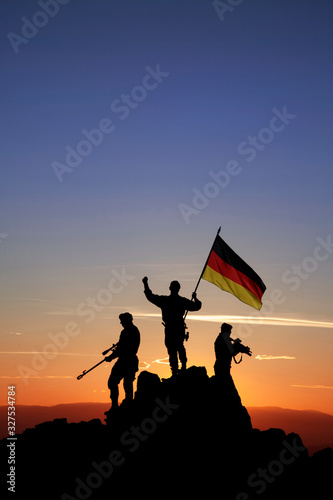 Three armed soldiers with the German flag photo