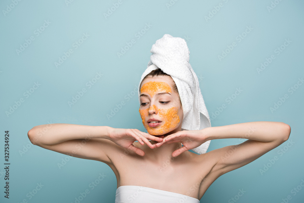 pensive girl with citrus facial mask holding hands near face on blue background pensive girl with citrus facial mask holding hands near face on blue background