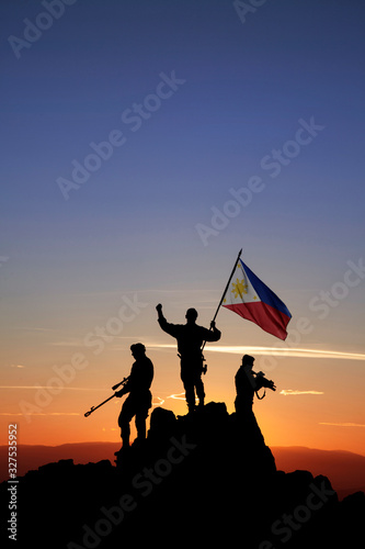 Three armed soldiers with the Philippine flag