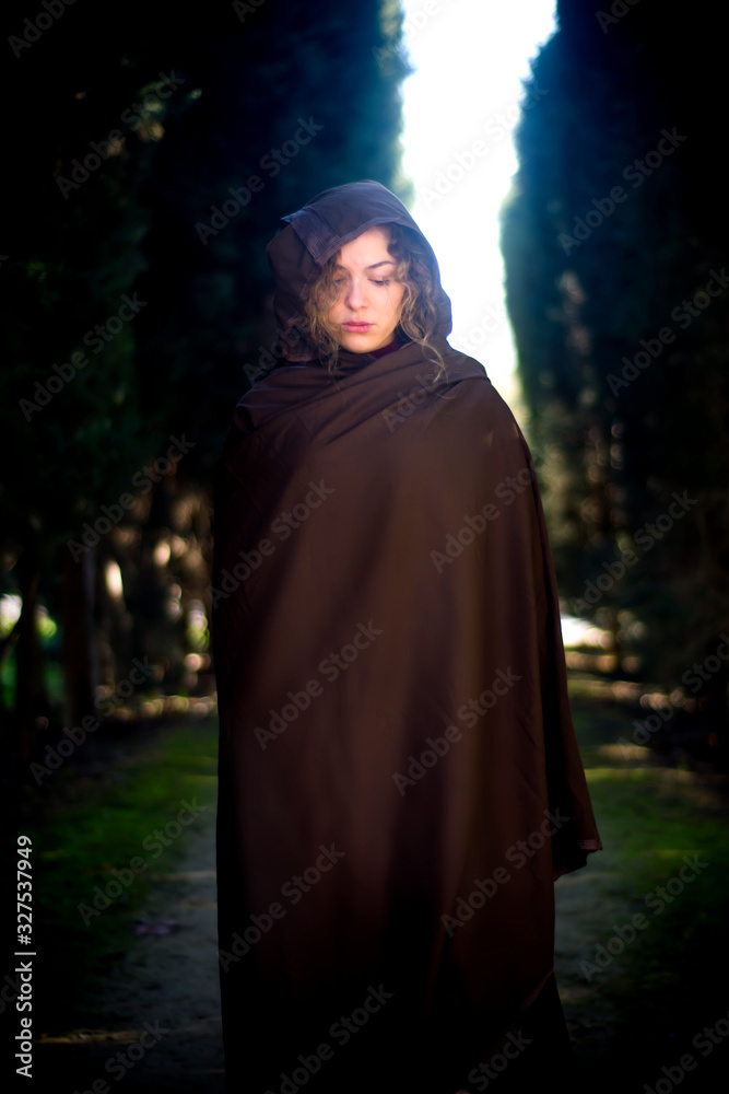 Beautiful woman with cape on a path in the woods Beautiful woman with cape on a path in the woods