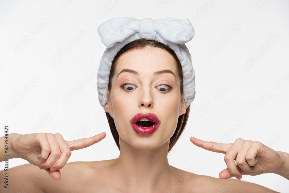 excited girl pointing with fingers at collagen patch on lips isolated on white excited girl pointing with fingers at collagen patch on lips isolated on white