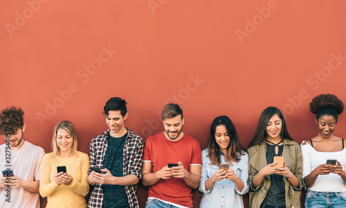 Group young people using mobile smartphone outdoor - Millennial generation having fun with new trends social media apps - Youth technology addicted - Red background photo