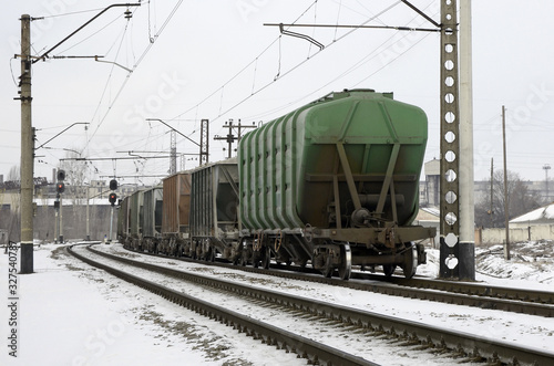 railroad hopper cars parked on rural tracks all by themselves on a cold winter day.