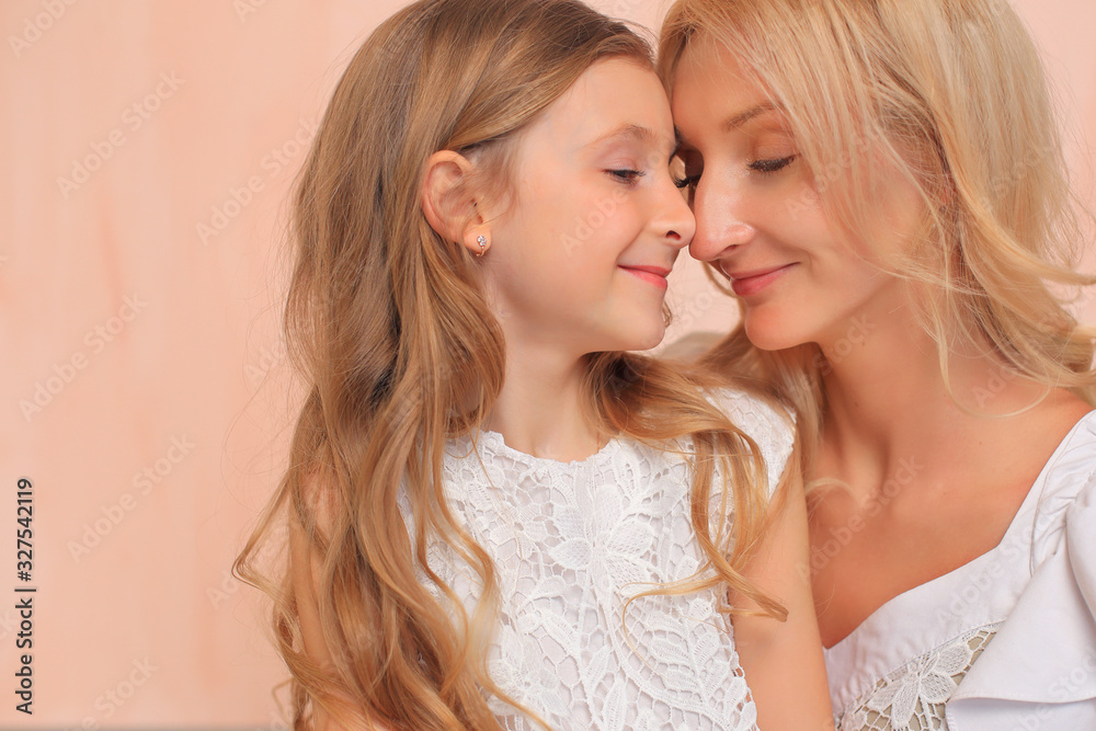 Mom with her daughter in white dresses in the studio. Mom with her daughter in white dresses in the studio.