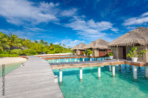 Exotic landscape of Maldives beach. Tropical panorama, luxury water villa resort with wooden pier or jetty. Luxury travel destination background for summer holiday and vacation concept.