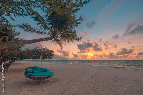 Tropical beach sunset as summer landscape with luxury resort beach swing or hammock and white sand and calm sea for sunset beach landscape. Tranquil beach scenery vacation and summer holiday concept.
