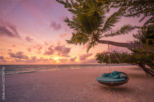 Fototapeta Naklejka Na Ścianę i Meble -  Tropical beach sunset as summer landscape with luxury resort beach swing or hammock and white sand and calm sea for sunset beach landscape. Tranquil beach scenery vacation and summer holiday concept.