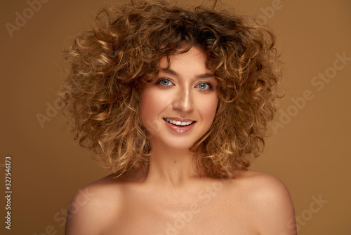 Portrait of pretty young blonde woman with curly hair