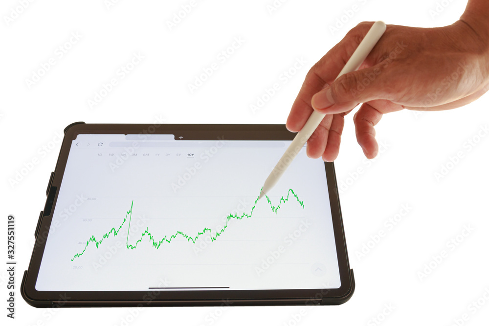 The graph shows the results of stock fluctuations on tablets.Hand holding pen check on display The graph shows the results of stock fluctuations on tablets.Hand holding pen check on display