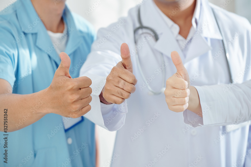 Close-up image of physicians and surgeon showing thumbs-up after patients recovery Close-up image of physicians and surgeon showing thumbs-up after patients recovery