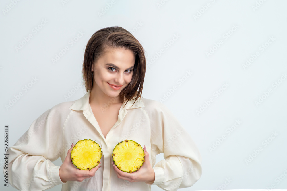 Two halves of pineapple in hands of woman. Two halves of pineapple in hands of woman.