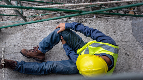 Knee accident at work of construction worker at site. Builder accident falls scaffolding on floor.