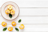 Healthy food. Ripe sliced peaches on plate on white wooden table top-down copy space