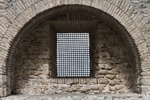 Window with fence in an old wall of Vejer de la Frontera, Spain
