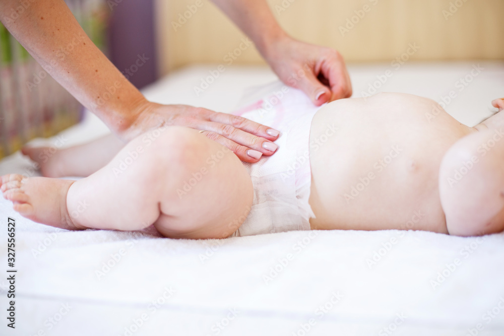 mother changing the diaper of her baby at home mother changing the diaper of her baby at home