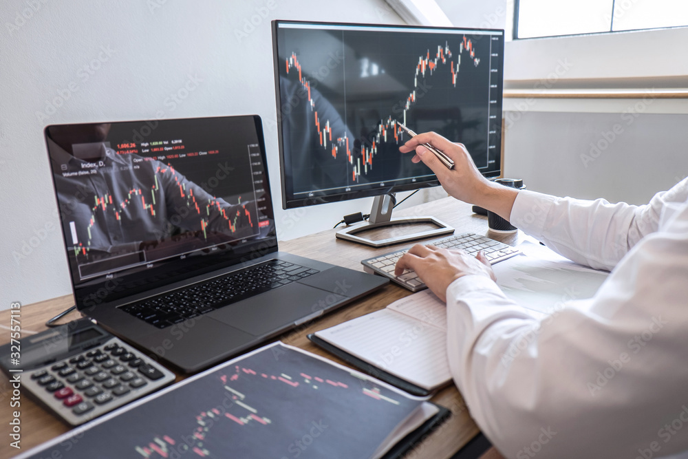 Stock exchange market concept, Business investor trading or stock brokers having a planning and analyzing with display screen and pointing on the data presented and deal on a stock exchange