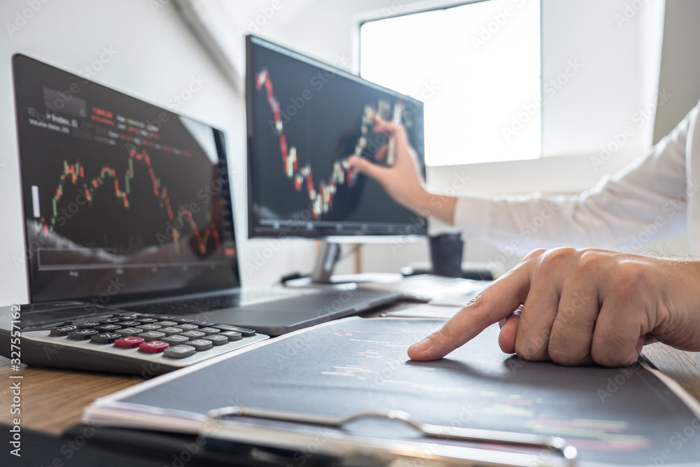 Stock exchange market concept, Business investor trading or stock brokers having a planning and analyzing with display screen and pointing on the data presented and deal on a stock exchange Stock exchange market concept, Business investor trading or stock brokers having a planning and analyzing with display screen and pointing on the data presented and deal on a stock exchange