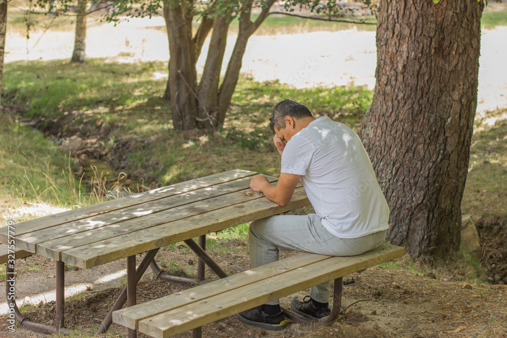 Fototapeta premium A man sat in the country in a silent and thoughtful position