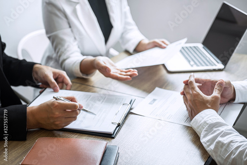 Fototapeta Employer or committee holding reading a resume with talking during about his pro