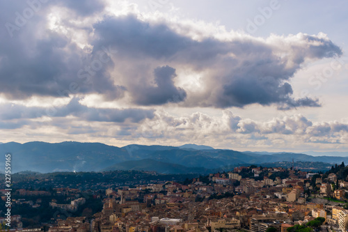 The panoramic view of a medieval French town in Côte d'Azur under the cloudy moody sky and warm sunlight