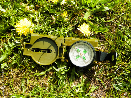 Compass on grass - traveling, exploration and navigation.