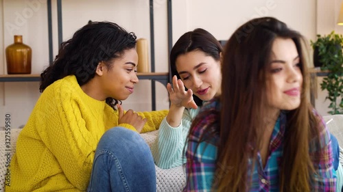 Sneaky girls sitting at home and gossiping about their roommate