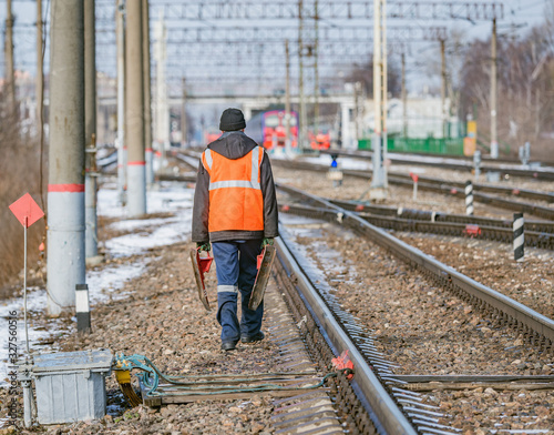 Railway worker walks on railway station territory.